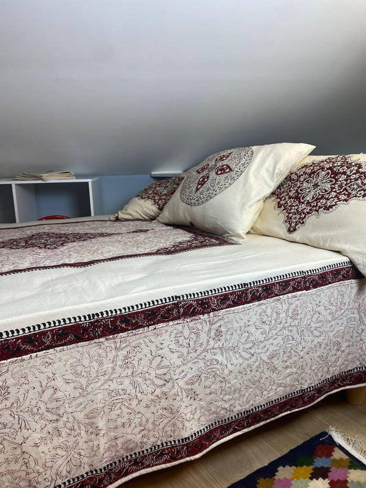 Lit élégant décoré avec plaid artisanal et coussins en tissu tissé main – linge de maison Chez Scheyda